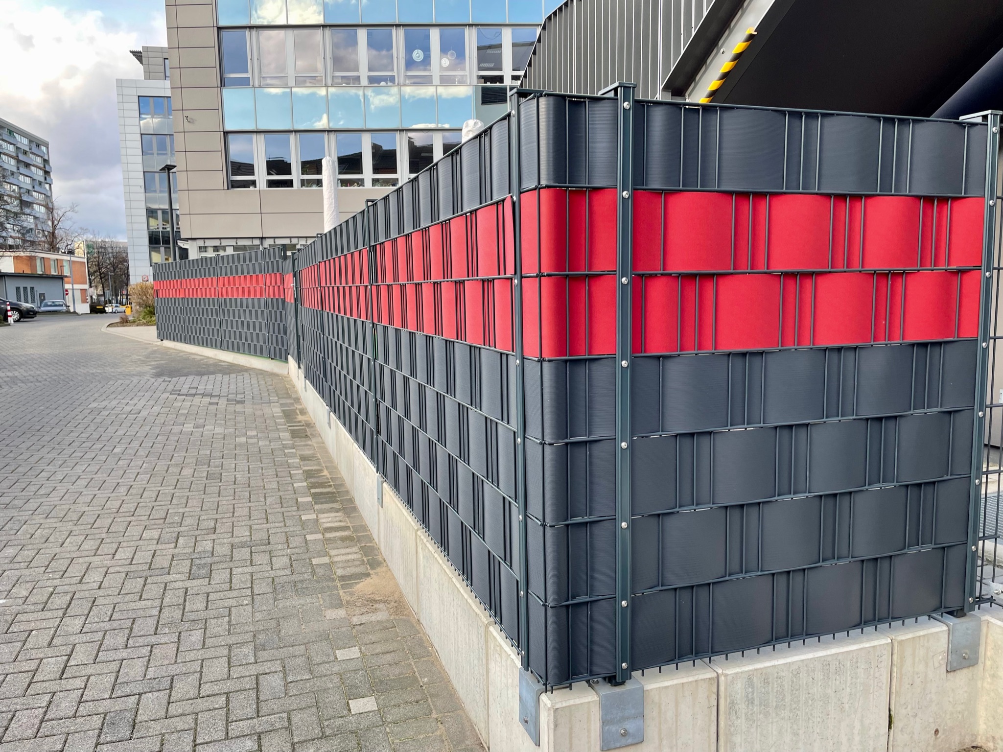 Sichtschutzzaun mit rotem Streifen kombiniert